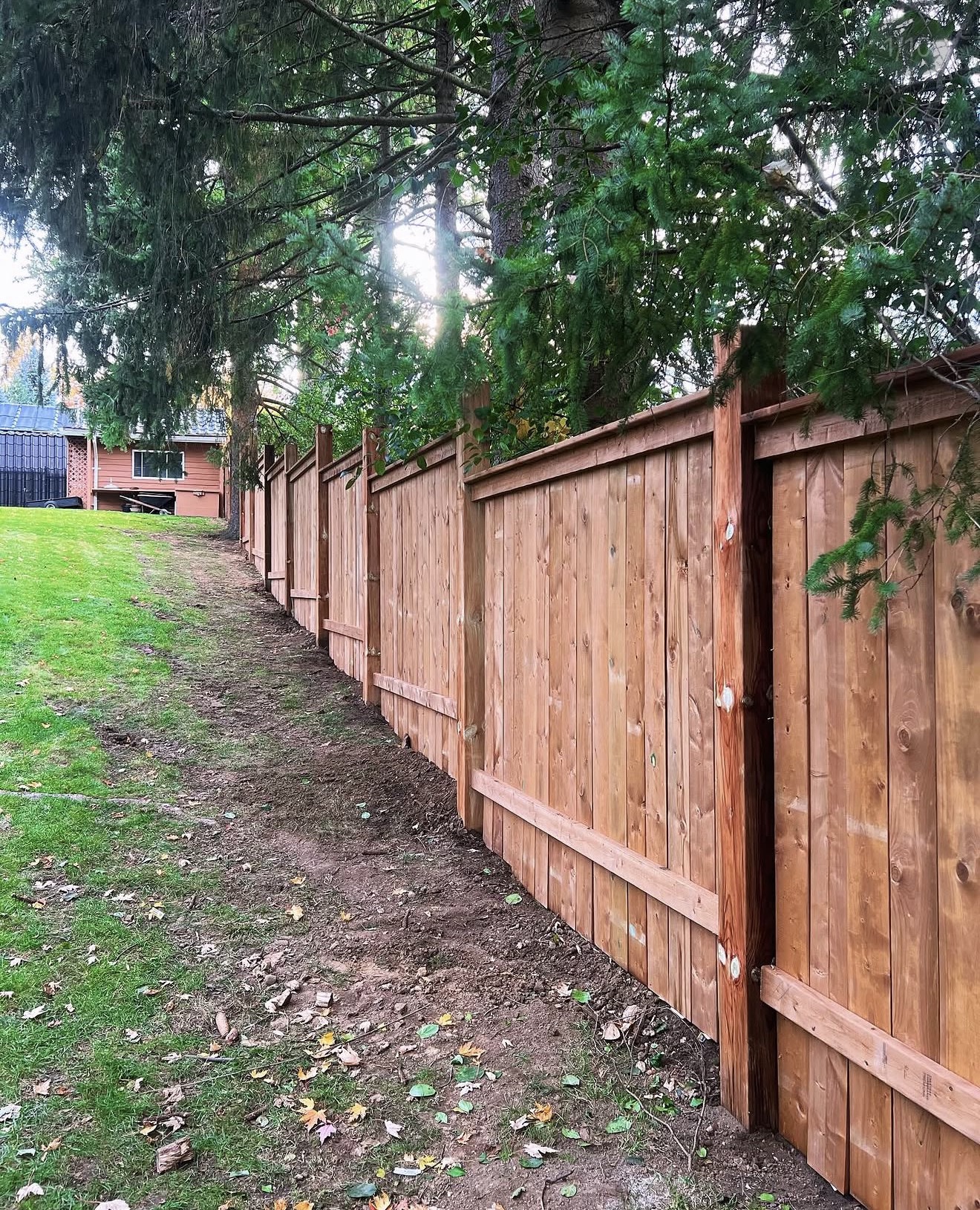 Board-on-board full privacy fence following a sloped yard